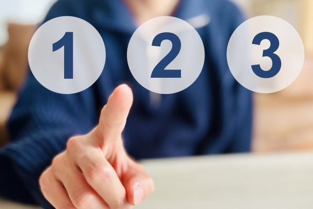 １２３を指さす男性