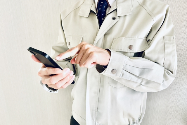 スマホを持つ作業員