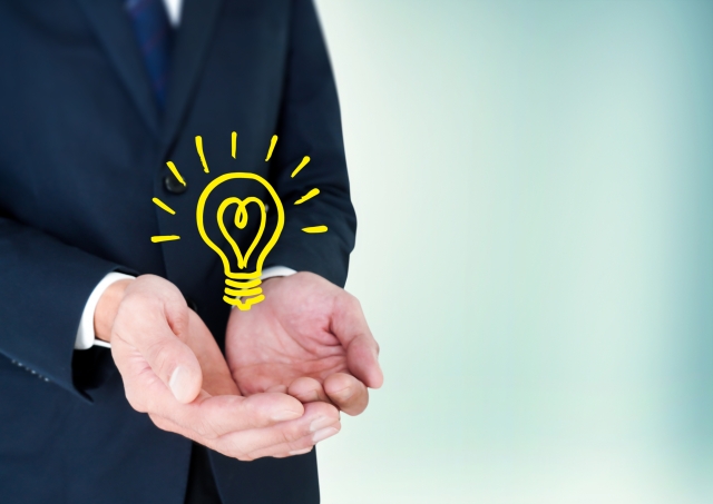 豆電球を持つビジネスマンの手元